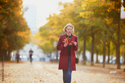 Young woman with bunch of colorful autumn leaves