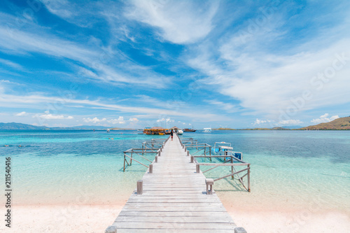 View of the wooden pier from the coast of Kanawa Island with turquoise sea and sand beach, Komodo Island (Komodo National Park), Labuan Bajo, Flores, Indonesia