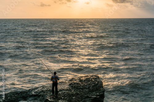 A fisherman looking to the sea in sunset time from Tanah Lot Temple, Bali, Indonesia
