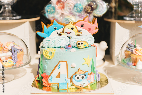 Candy bar for your birthday. Children's party in the nature. Beautiful cake with fish, candy and number 4