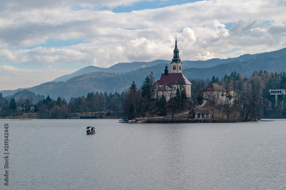 Bled Island in the winter to which a boat is approaching