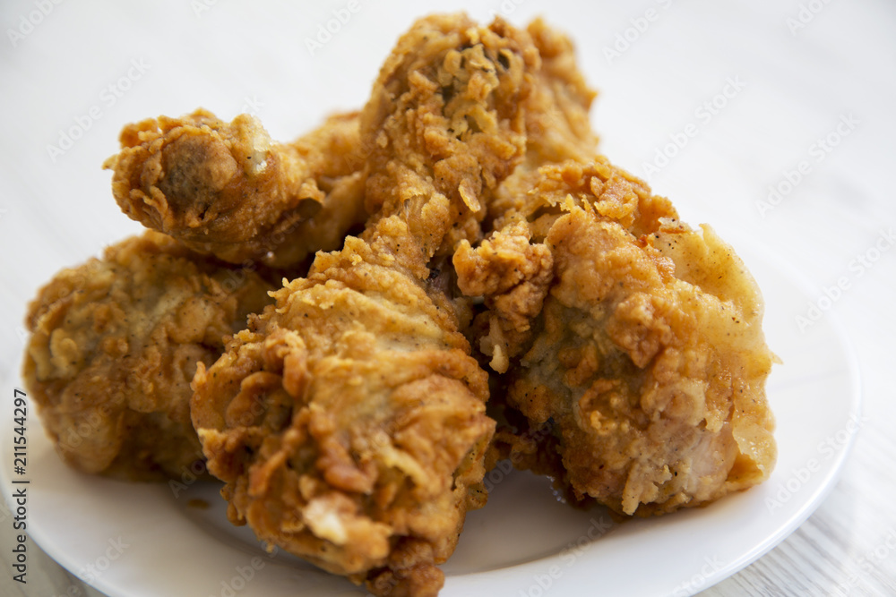 Fried chicken legs on a white plate, close-up. Fried chicken legs on a white plate, close-up.