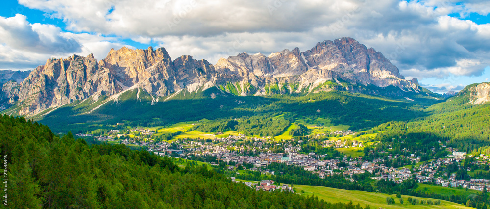 Fototapeta premium Panorama of Cortina d'Ampezzo with green meadows and alpine peaks on the background. Dolomites, Italy
