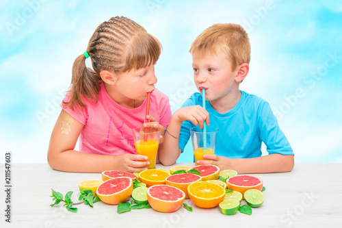 children drinking juice frome fresh orange and grapefruit