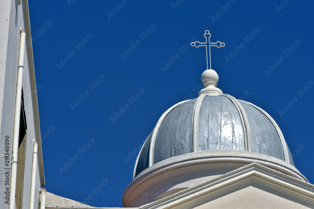Dome church, with crucifix, under blue sky