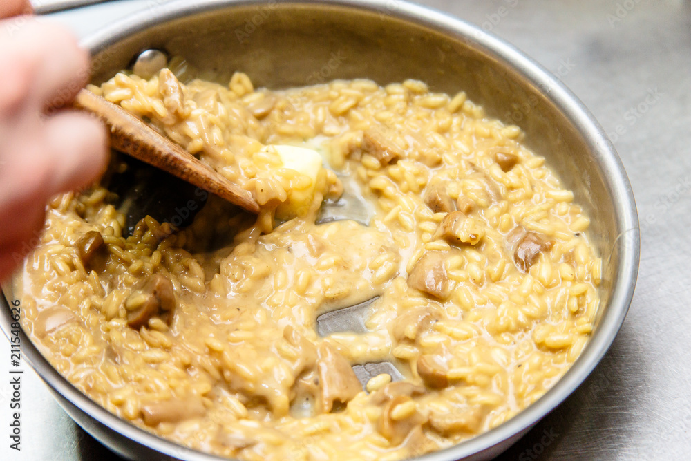 Preparation of risotto with mushrooms in the restaurant kitchen. Preparation of risotto with mushrooms in the restaurant kitchen.