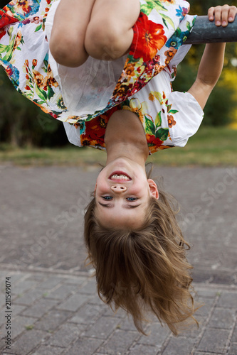Young girl hangin upside down outdoor