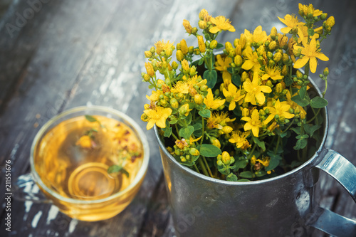  St Johns wort flowers in a large retro mug and Healthy hypericum tea - not in focus. photo
