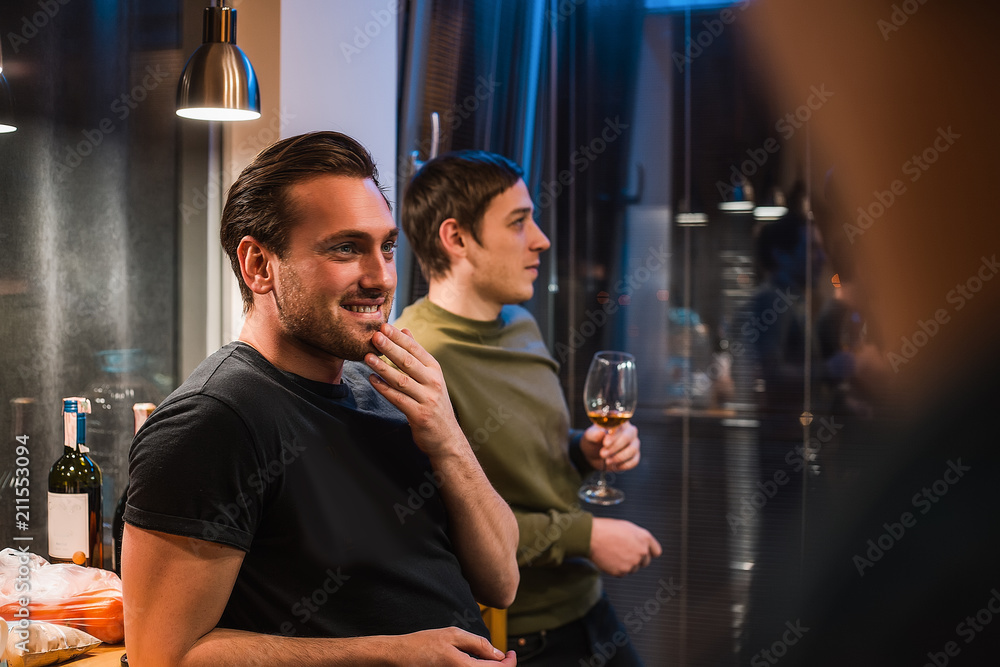 Attractive stylish man pretty hairstyle have conversation on home party under beautiful light