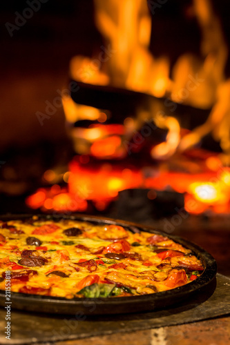 Pizza Oven Pizza shallow depth of field with fire burning in background