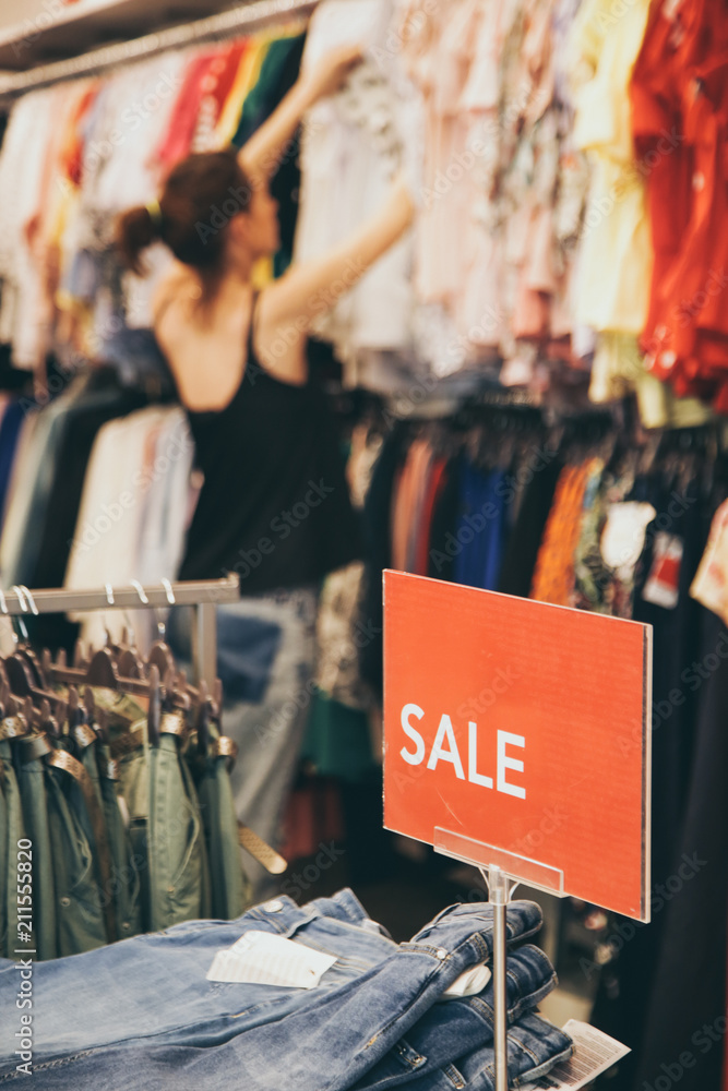 Woman looking clothes on discount in the shopping mall, seasonal sale concept
Woman looking clothes on discount in the shopping mall, seasonal sale concept