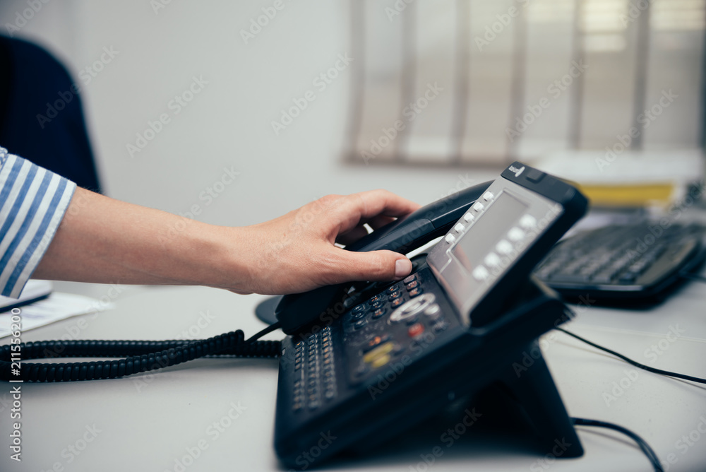 Closeup on busy office phone workplace, light table window. Modern administration control lcd display support solution response. Digital connection device communication landline equipment technology