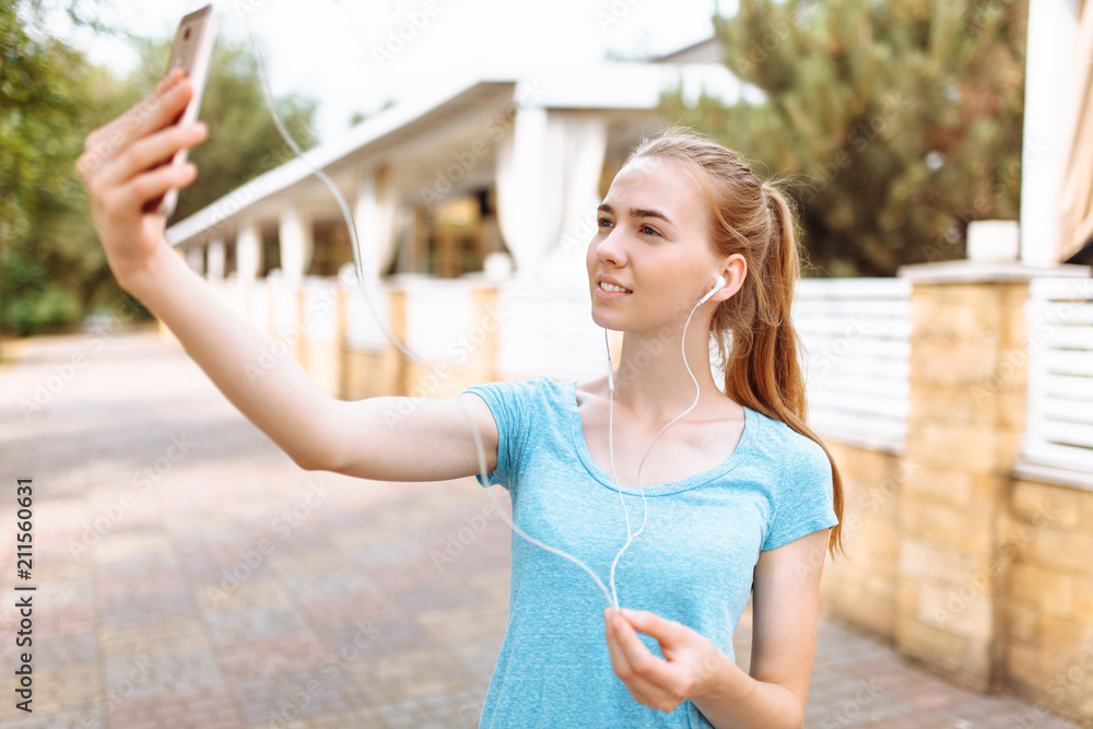 Girl after a morning jog takes a selfie on the phone, training