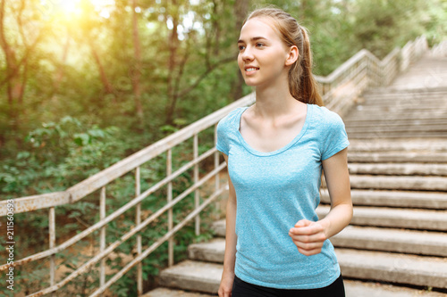 Beautiful young girl is Jogging on the steps, morning jog in the forest