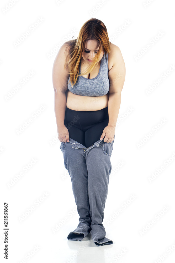 Fat woman trying to wear tight jeans on studio Stock Photo | Adobe Stock