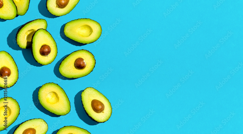Fresh avocado pattern on a blue background flat lay Fresh avocado pattern on a blue background flat lay