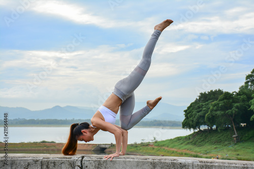 Young healthy woman doing yoga exercises, relax with nature time.