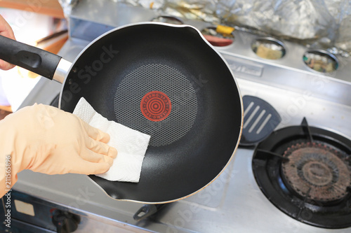 Cropped image of woman washing frying pan in kitchen. photo