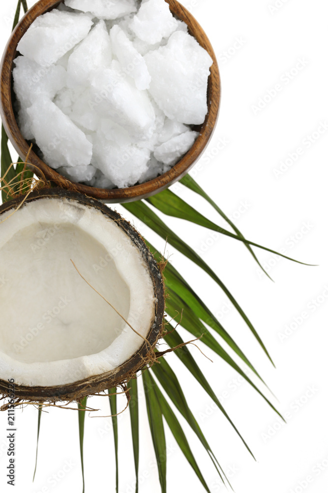 Coconut oil.pure natural coconut oil in a wooden round bowl, half fresh coconut and a palm leaf isolated on a white background. Coconut oil.pure natural coconut oil in a wooden round bowl, half fresh coconut and a palm leaf isolated on a white background.