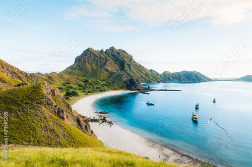 Coast view of Padar Island in a cloudy morning with blue water surface and tourist boats, Komodo Island (Komodo National Park), Labuan Bajo, Flores, Indonesia photo