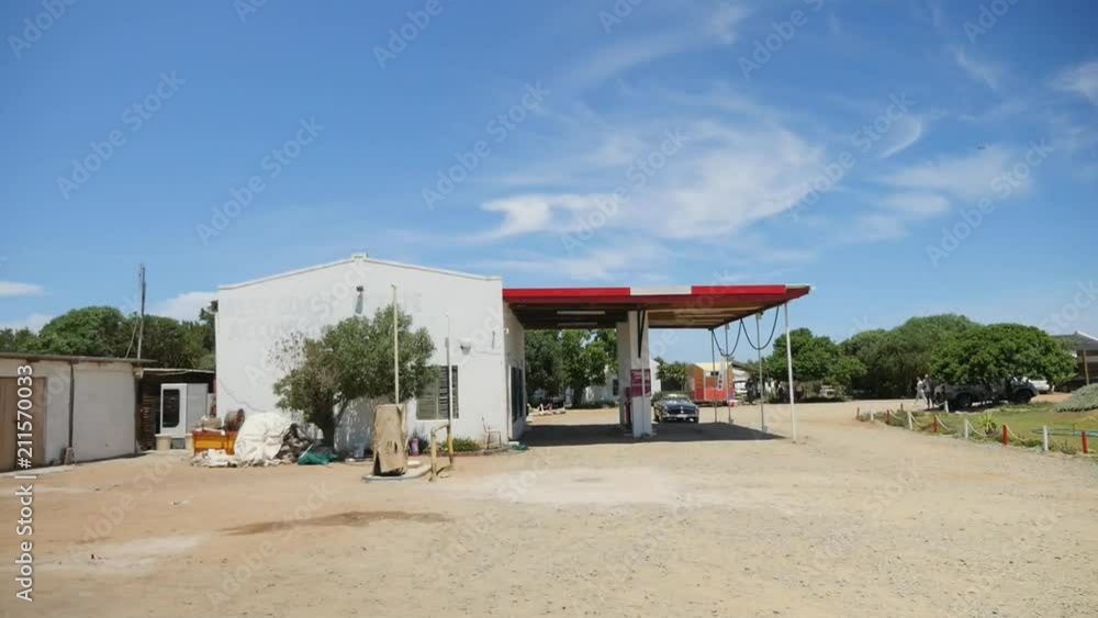 An old gas station in the middle of nowhere with a classic black convertible car waiting for an attendant. An old gas station in the middle of nowhere with a classic black convertible car waiting for an attendant.