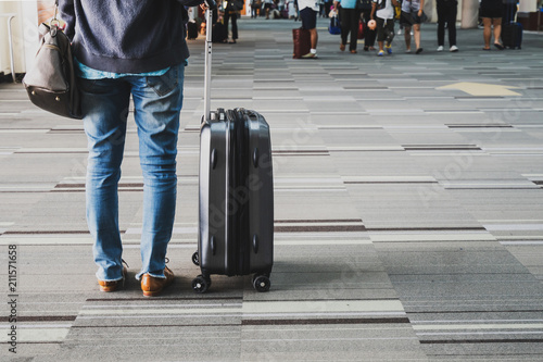 Young woman traveler walking in airport terminal hall with laggage photo