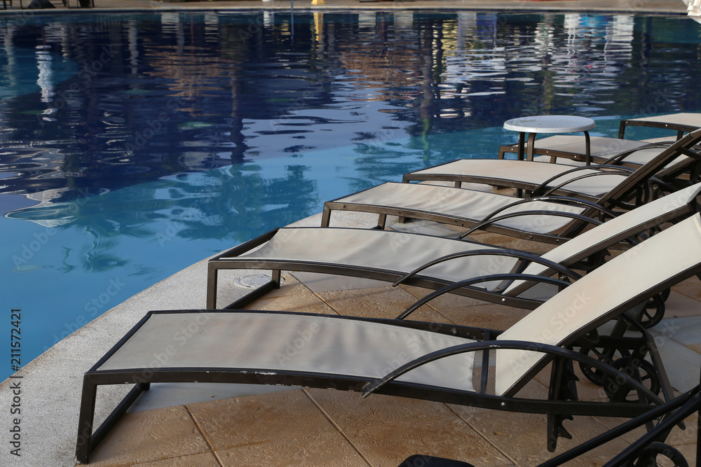 Loungers at the edge of the pool Loungers at the edge of the pool
