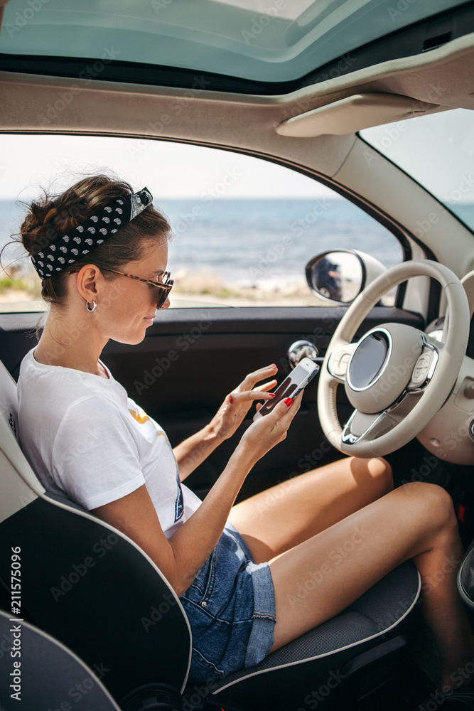 Young woman traveler on car near the sea