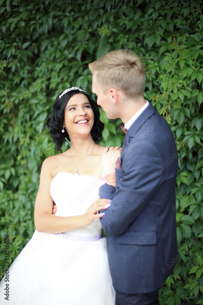 bride and groom on a background of green leaves bride and groom on a background of green leaves