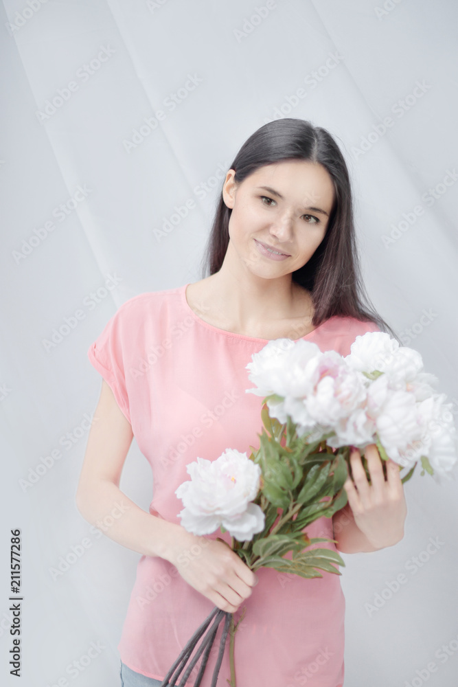 portrait of a young woman with a bouquet of peonies