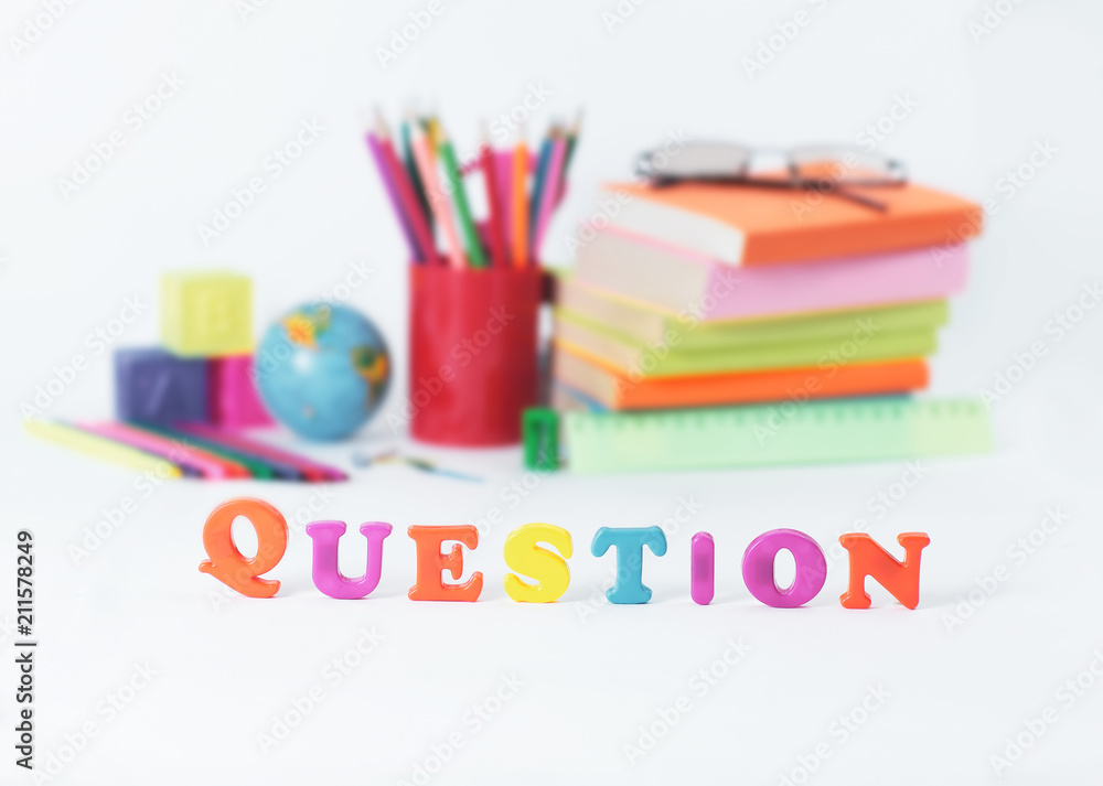 word question on blurred background of school supplies .photo with copy space word question on blurred background of school supplies .photo with copy space