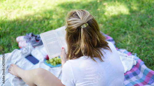 Woman reading book having a picnic