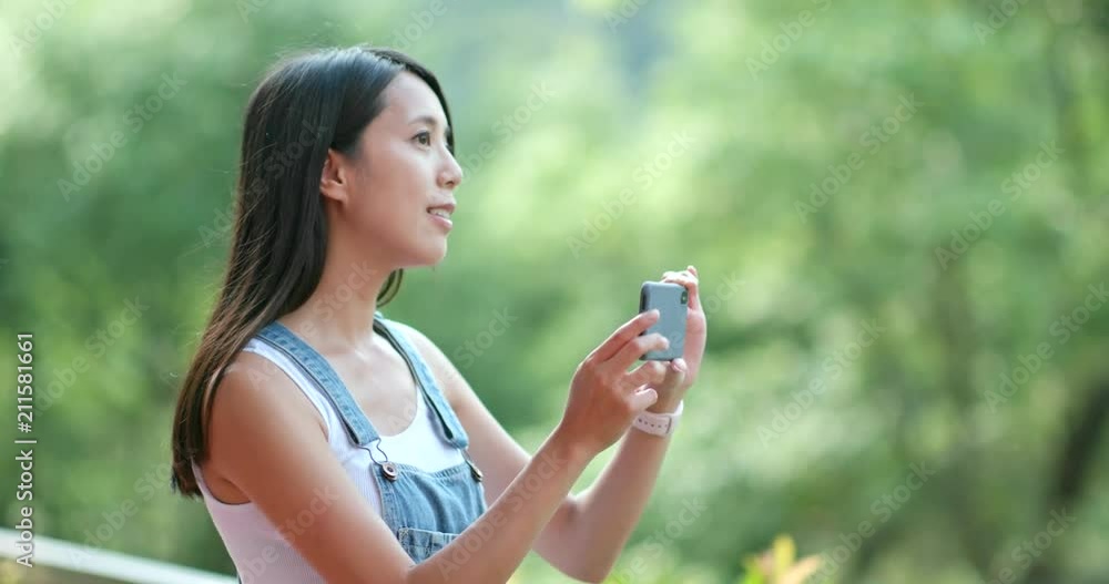 Woman taking photo by cellphone in the countryside Woman taking photo by cellphone in the countryside
