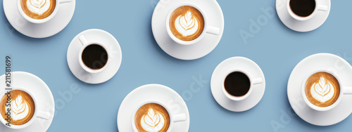 Fototapeta Wiele filiżanek kawy i cappuccino z latte art na niebieskim tle. Widok z góry, baner dla witryny.