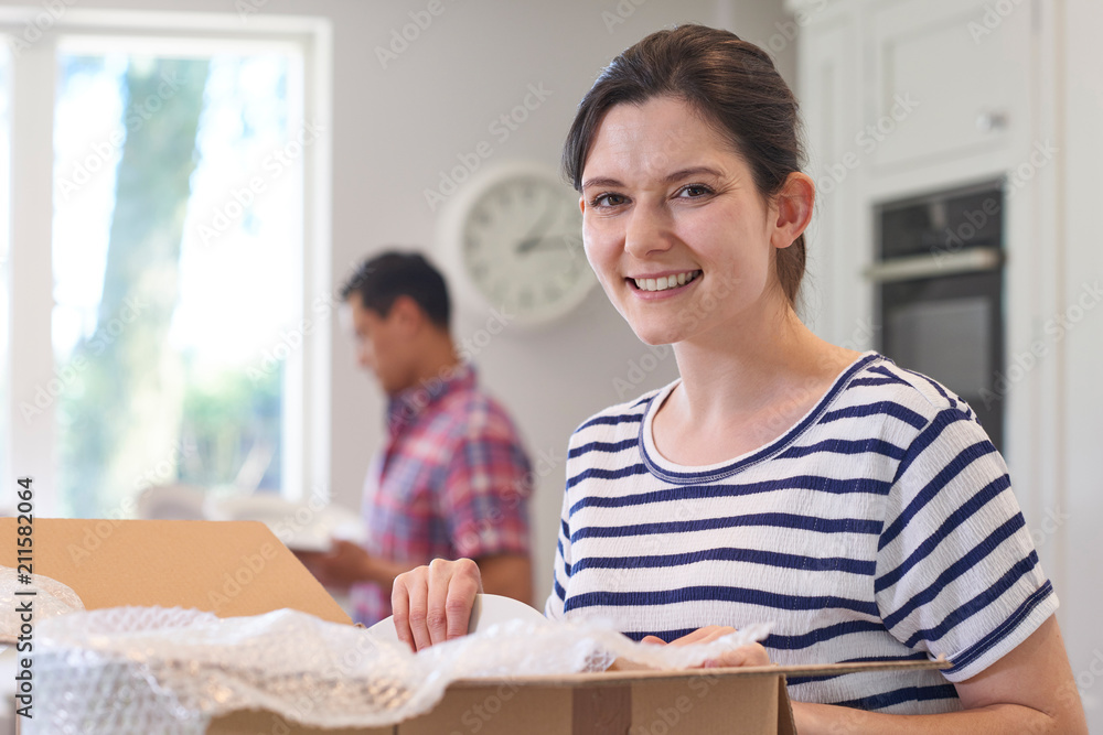 Portrait Of Young Couple Unpacking Boxes In Kitchen On Moving Day Portrait Of Young Couple Unpacking Boxes In Kitchen On Moving Day
