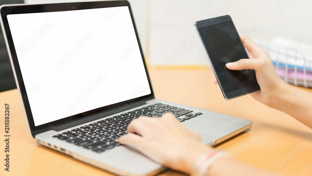 Business woman working on a computer and contacting a job on a smartphone.Business woman working at office with laptop and documents on her desk.business concept.Idea presentation. Business woman working on a computer and contacting a job on a smartphone.Business woman working at office with laptop and documents on her desk.business concept.Idea presentation.