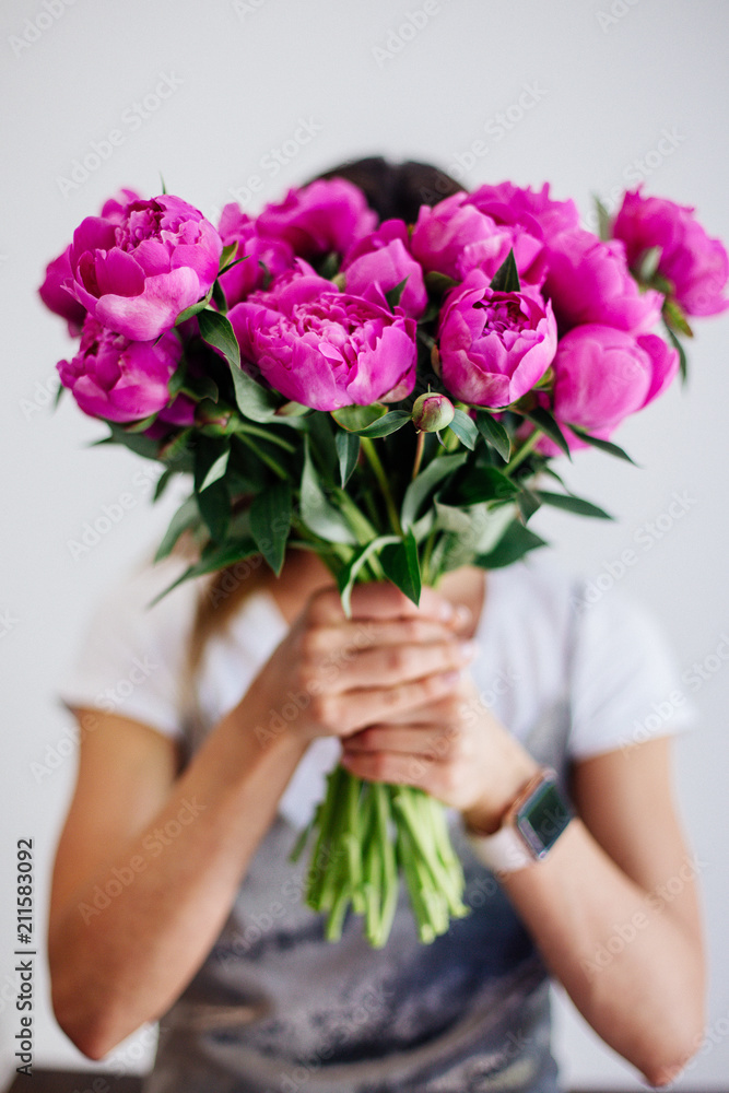 Bouquet of peonies in hands.