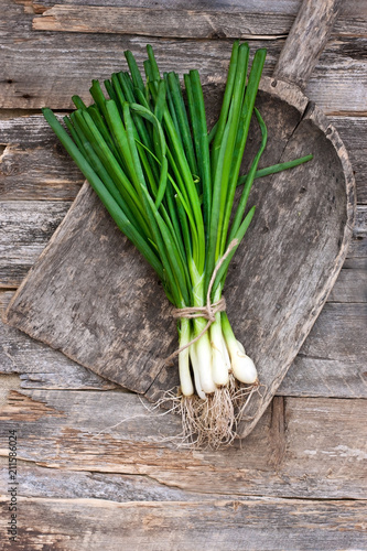 Bunch of green peeled onions on  wooden table