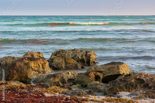Rocks on the shores of the Caribbean Sea lit by the setting sun, Cancun, Mexico