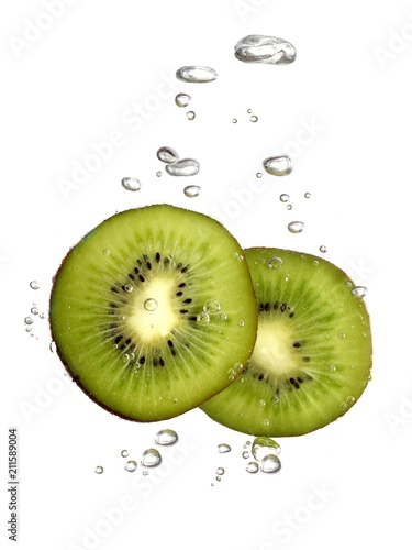 Bubbles forming in water after kiwi dropped into it.