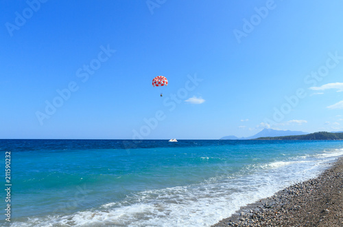 Turquoise sea and motor boat with a parachute in Kemer