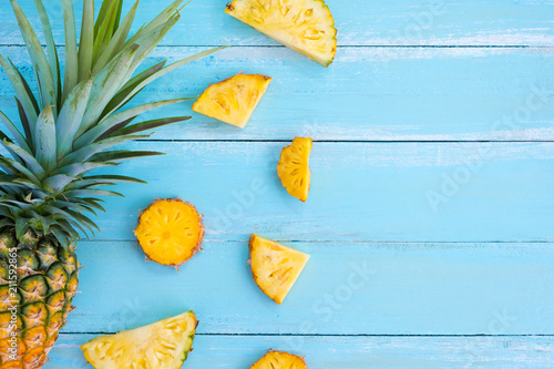 Tropical pineapple slices on wood plank blue color. frame layout summer vacation background concept. top view, pattern.