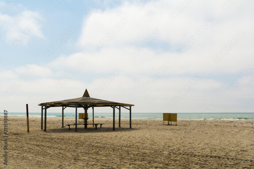 Sunbeds and umbrellas on the beach. Off season concept Sunbeds and umbrellas on the beach. Off season concept