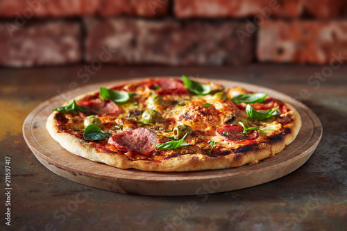 Thin crust pizza with ham, cheese and olive. Freshly baked pizza (from wood-fired oven). 