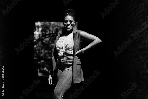 Stylish african american woman posed on tonnel arch at sunny day.