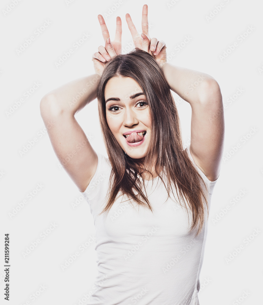 Portrait of a smiling happy woman showing victory sign and looking at camera Portrait of a smiling happy woman showing victory sign and looking at camera