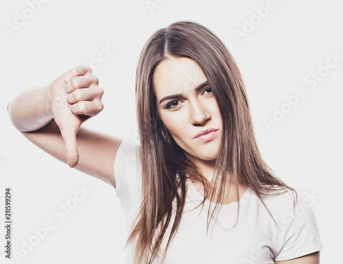 young woman showing a thumb down, do not like it, portrait, life style and people concept