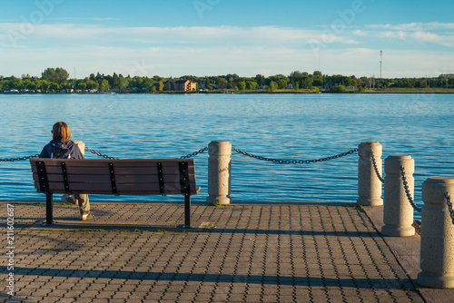 Obraz na plátně Female tourist sitting at the shore of St