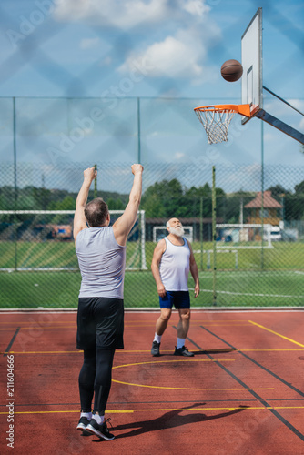 elderly men playing basketball together on playground on summer day © LIGHTFIELD STUDIOS
