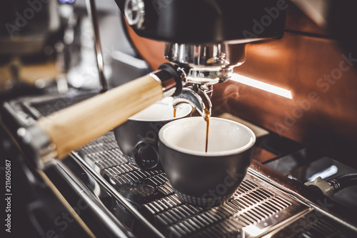 Espresso poruing from coffee machine at cafe Fototapeta
